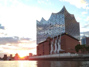 Edificio accanto a un lago con riflessi sull'acqua al tramonto.