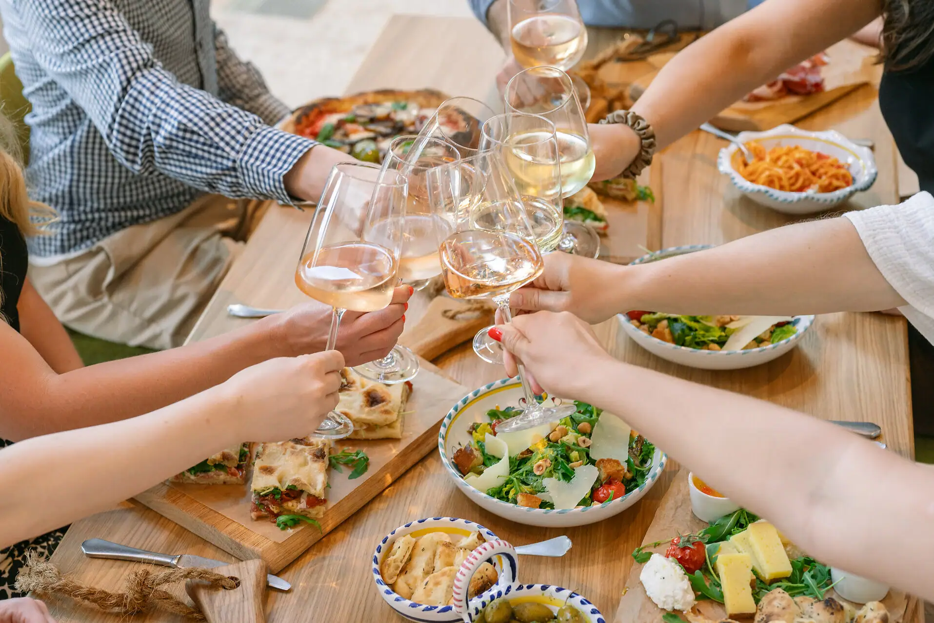 Un gruppo di persone che tiene bicchieri di vino.