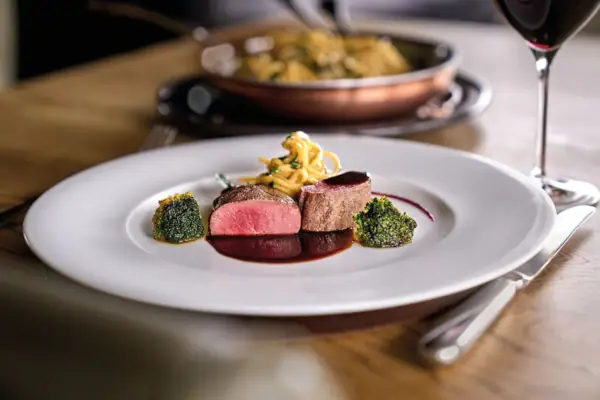 Ein Teller mit kunstvoll angerichteter Speise auf einem Tisch.