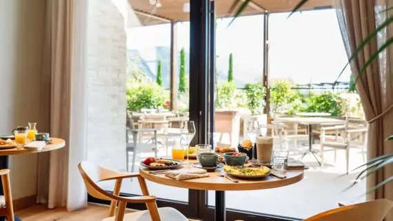 Tavolo con cibo in una sala da pranzo arredata con stile, vicino a una finestra.