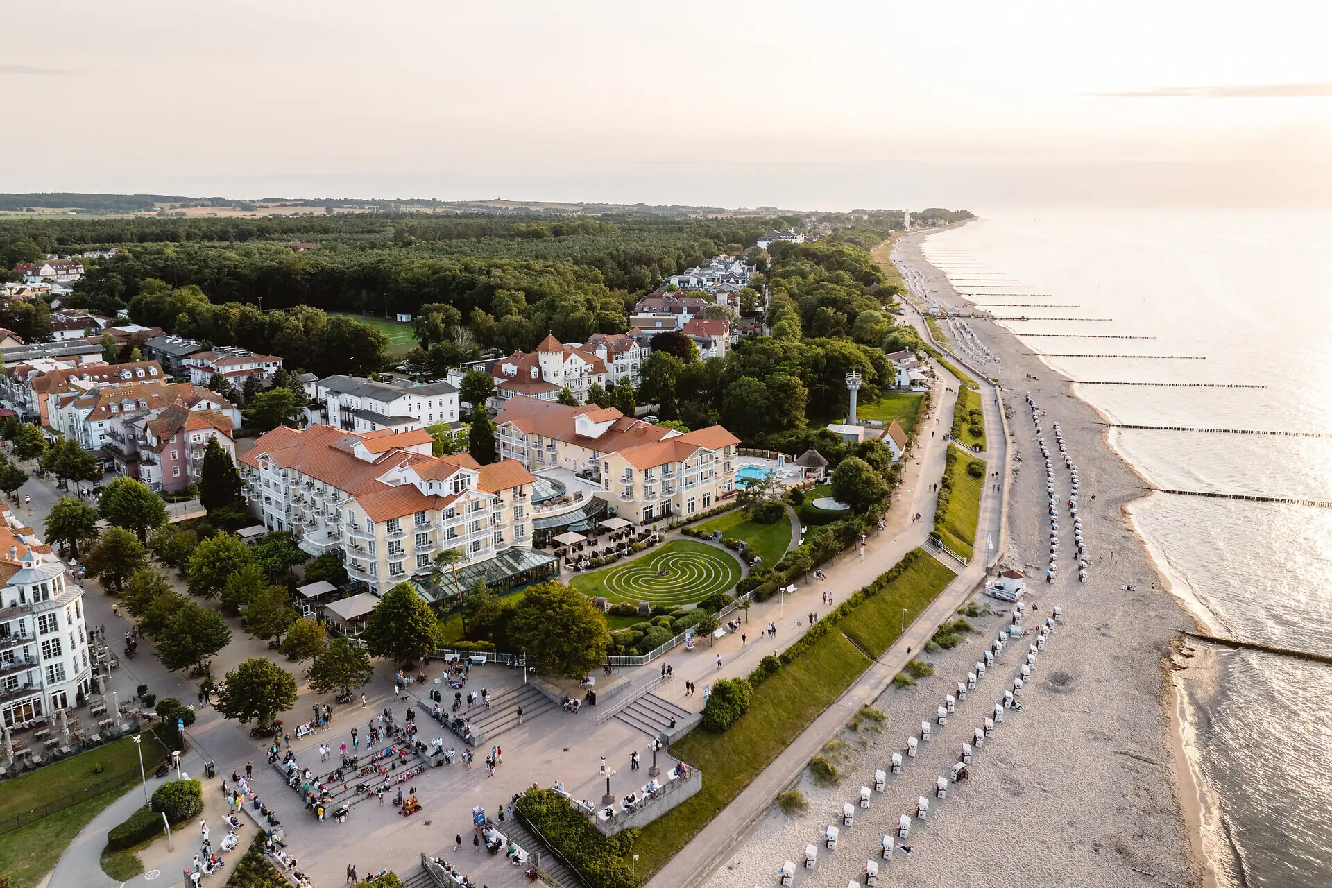 A-ROSA Ostseehotel Kühlungsborn Das A-ROSA Ostseehotel Kühlungsborn am Strand mit Bäumen aus der Vogelperspektive.