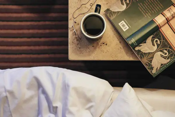 Tazza di caffè e libro su un tavolo.