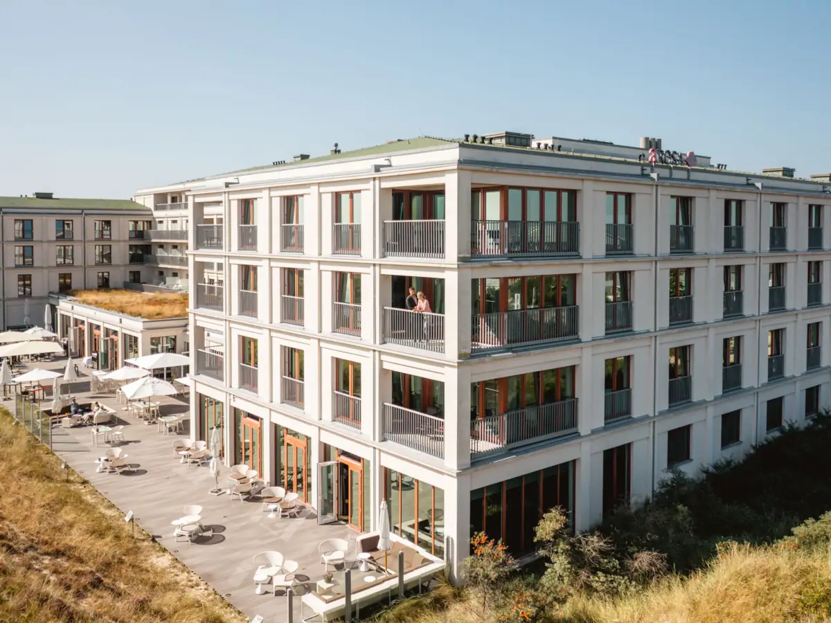 Das A-ROSA Hotel Sylt mit vielen Fenstern und einer Terrasse.