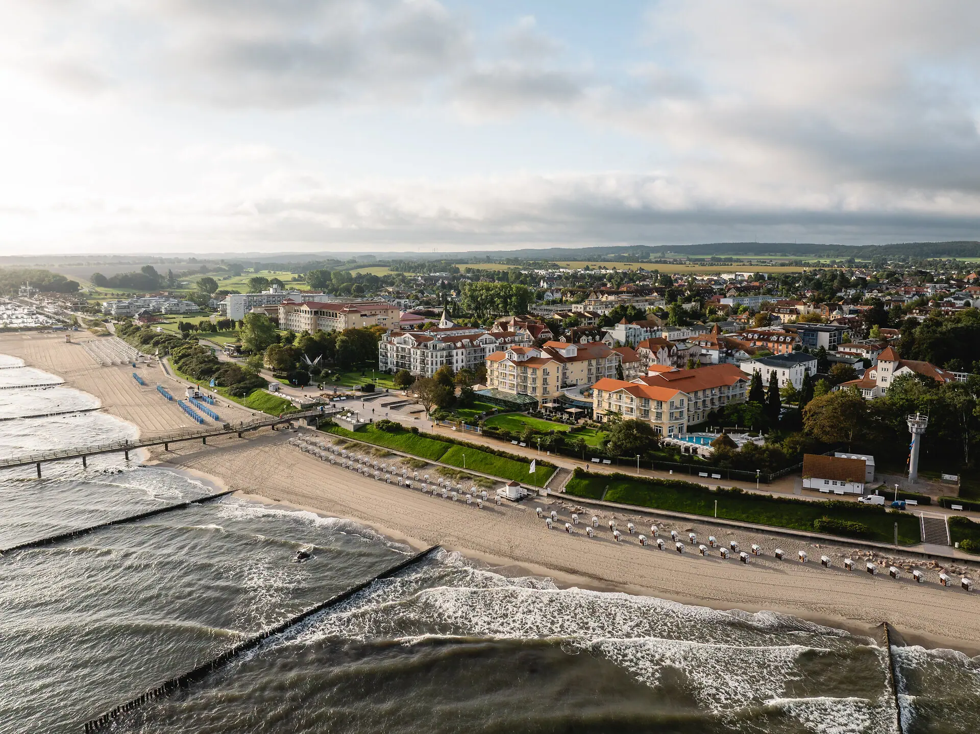 Strand mit Gebäuden und Wasser aus der Vogelperspektive.