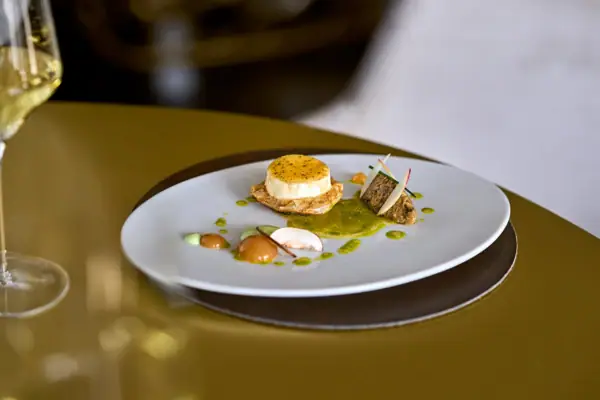 Ein Teller mit exquisit angerichteten Essen auf einem Tisch.