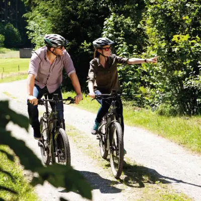 Un uomo e una donna stanno andando in bicicletta lungo un sentiero.