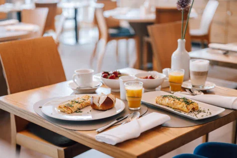 Tavolo con piatti di cibo e bevande in un ambiente interno.