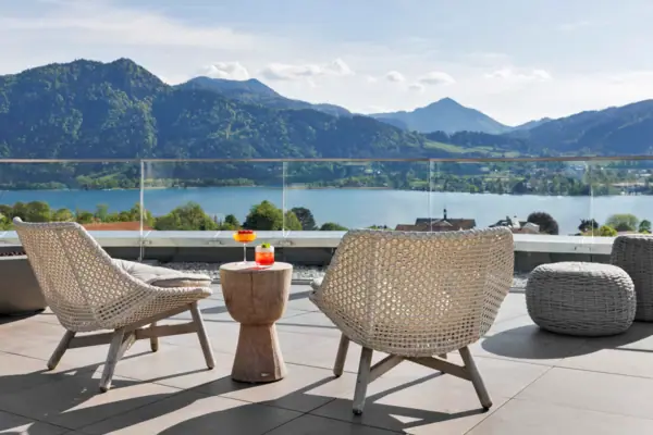 Un tavolo e delle sedie su una terrazza affacciata su uno specchio d'acqua.