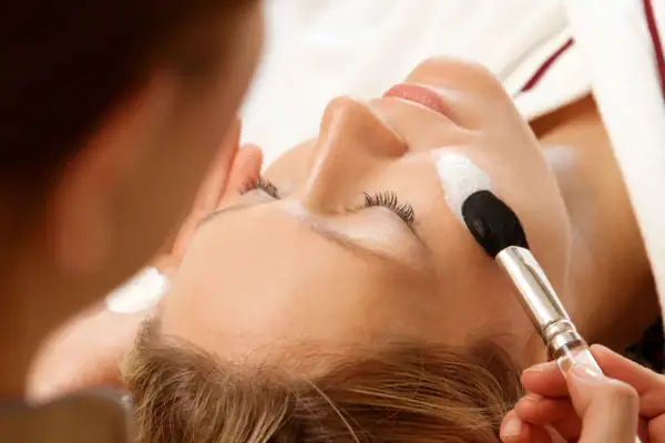 Eine Frau bekommt eine Gesichtsmaske aufgetragen.