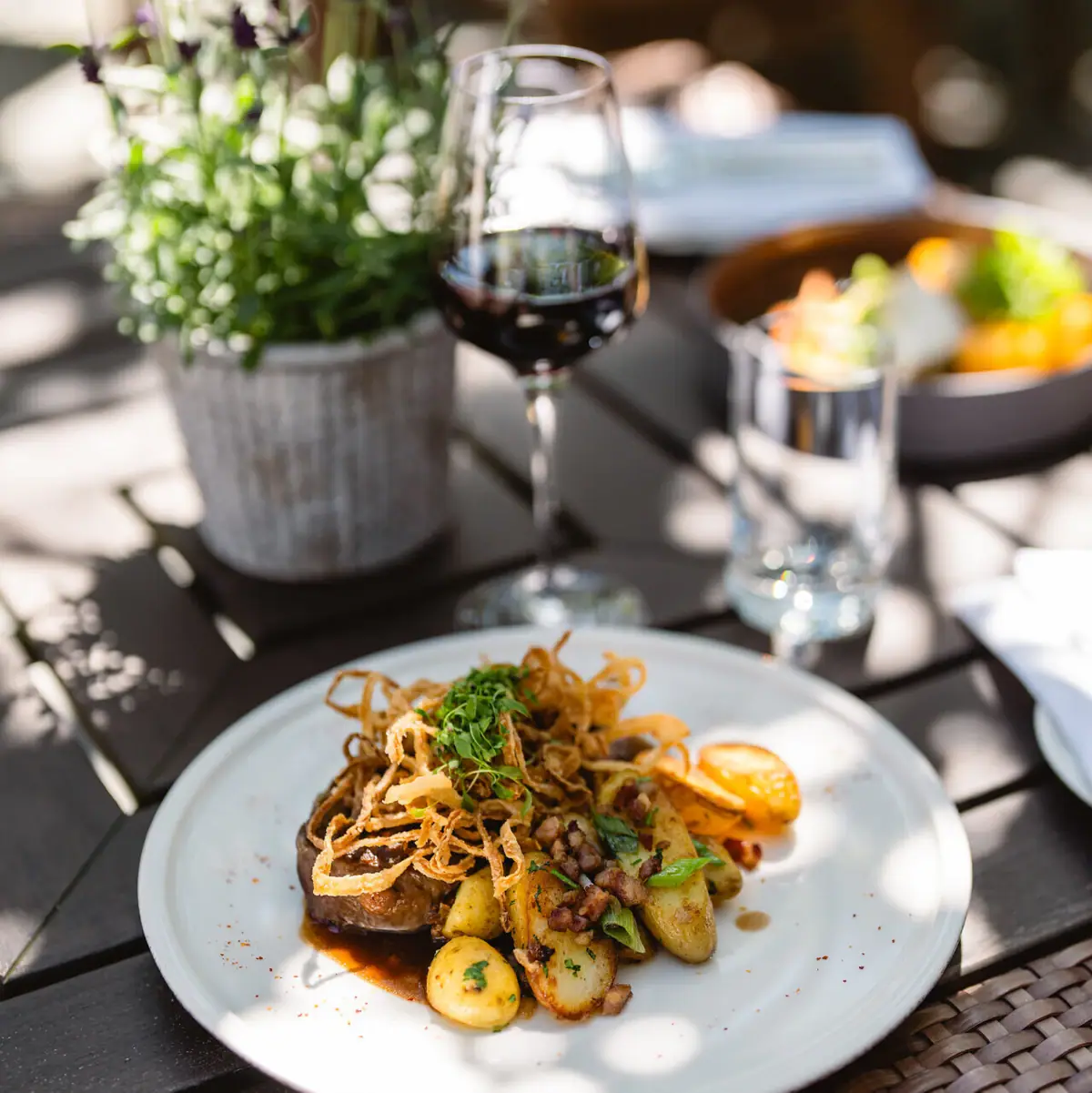 Gericht auf Teller Ein Teller mit Essen und ein Glas Wein.