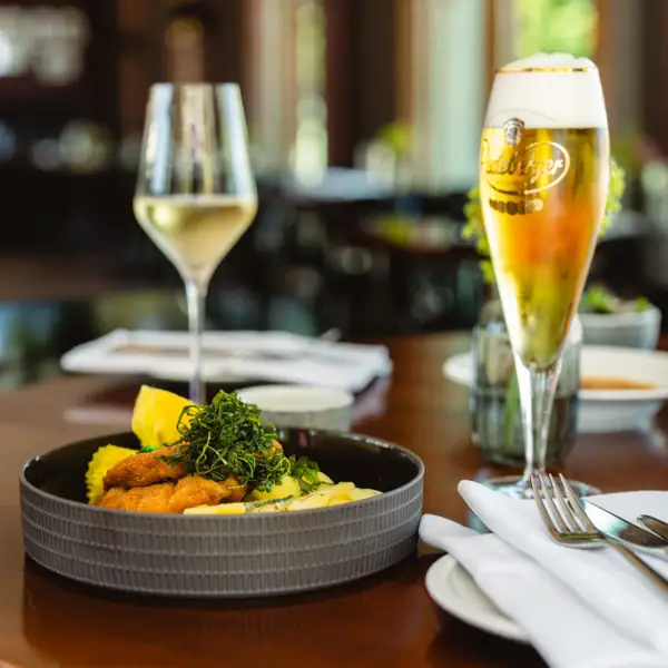 Gedeckter Tisch Ein Teller mit Essen und ein Glas Wein.