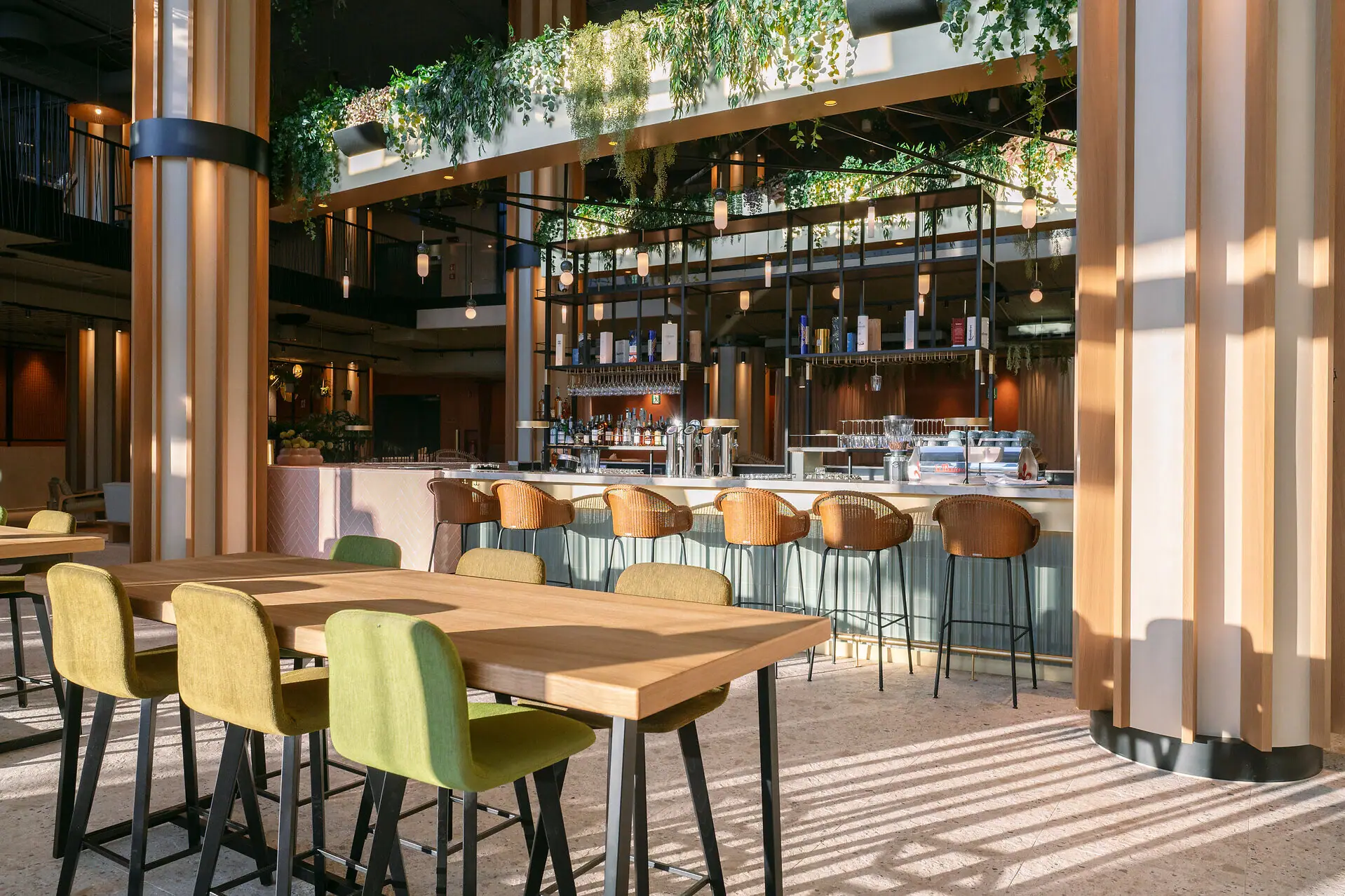 Bar elegante dell’Hotel A-ROSA Lago di Garda con tavoli moderni e atmosfera rilassata