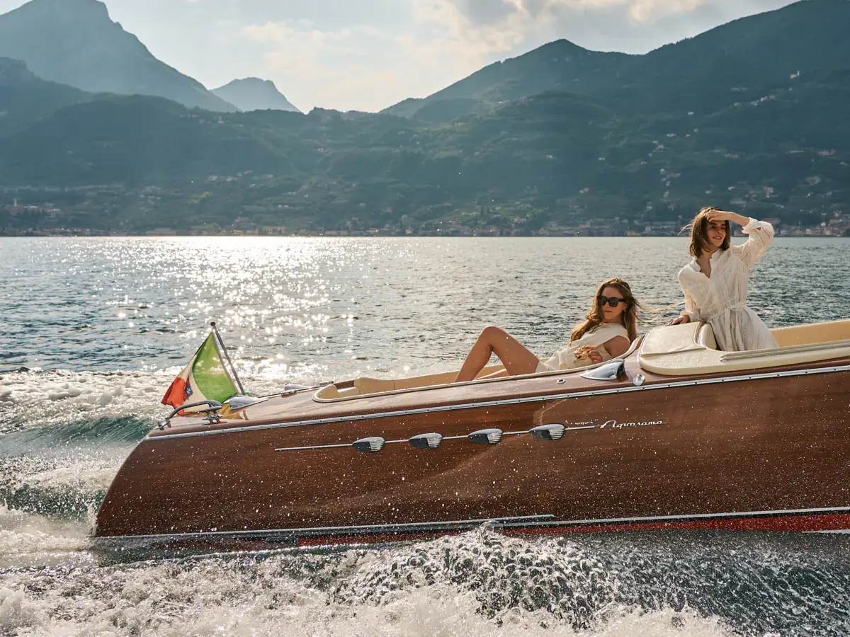 Ein Paar auf einem Boot auf dem Wasser mit Bergen im Hintergrund.