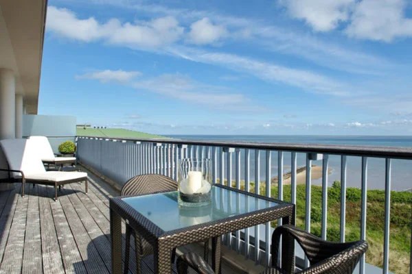 Tavolo e sedie su una terrazza con vista sull'acqua.