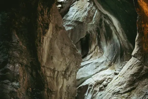 Cascata del Varone Grotta con un foro nella parete, circondata da formazioni rocciose naturali.