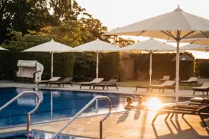 Una piscina all'aperto con ombrelloni e sedie a sdraio.