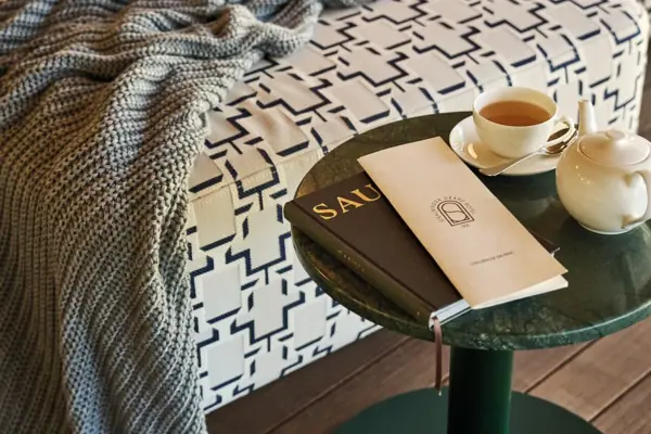 Un tavolo con un libro e una tazza di tè.
