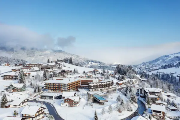 Verschneite Landschaft mit Gebäuden und Bäumen.