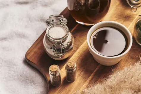 Tazza di tè con sale su un tagliere di legno.