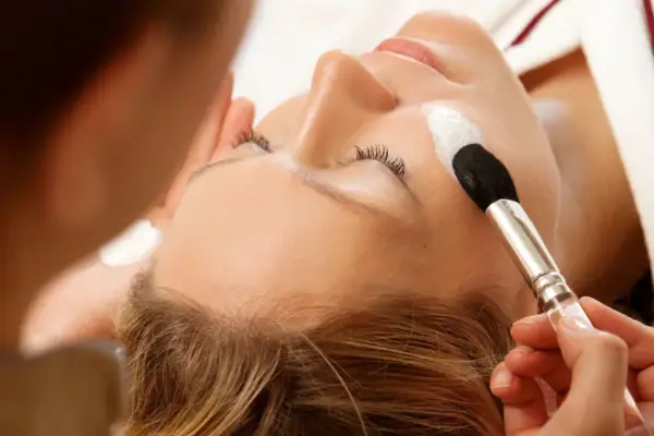 Eine Frau erhält eine Gesichtsmaske im Schönheitssalon.