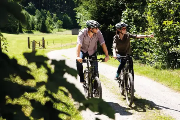 Ein Mann und eine Frau fahren auf einem Weg Fahrrad.
