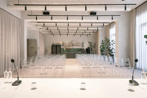 Ein Tagungsraum mit vielen klaren Stühlen.