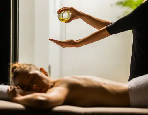 Eine Person gießt Öl in die Hand einer anderen Person.