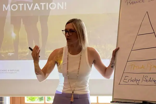 Eine Frau steht vor einem Bildschirm.