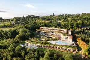Un edificio con piscina circondato da alberi.