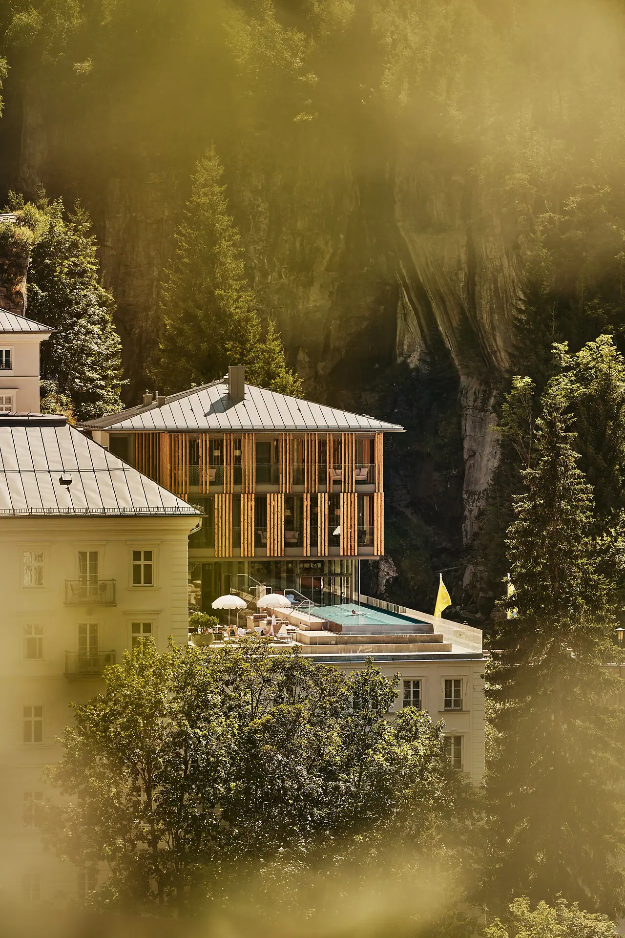 Gebäude mit Pool in der Mitte, umgeben von Bäumen und Pflanzen.