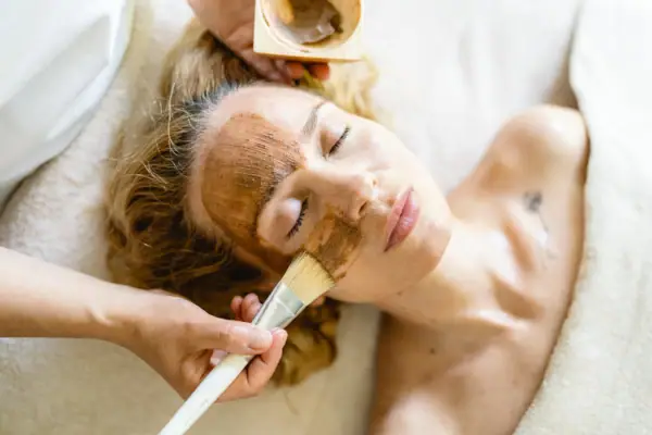 Eine Frau liegt mit einer braunen Maske im Gesicht.