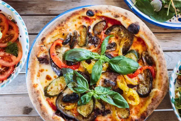 Pizza con verdure su un piatto.