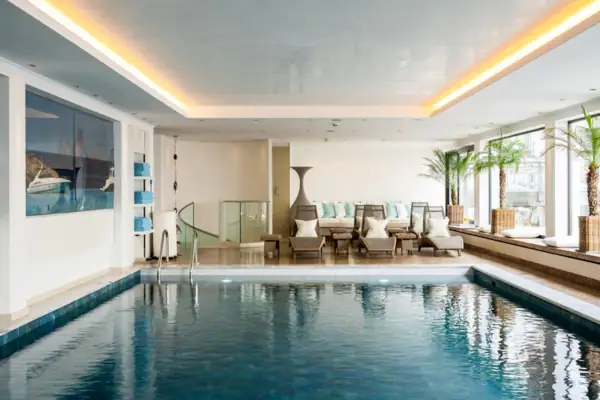 Alpenhof Schwimmbad Innenpool mit stilvollem Design und klaren Wasseroberfläche.