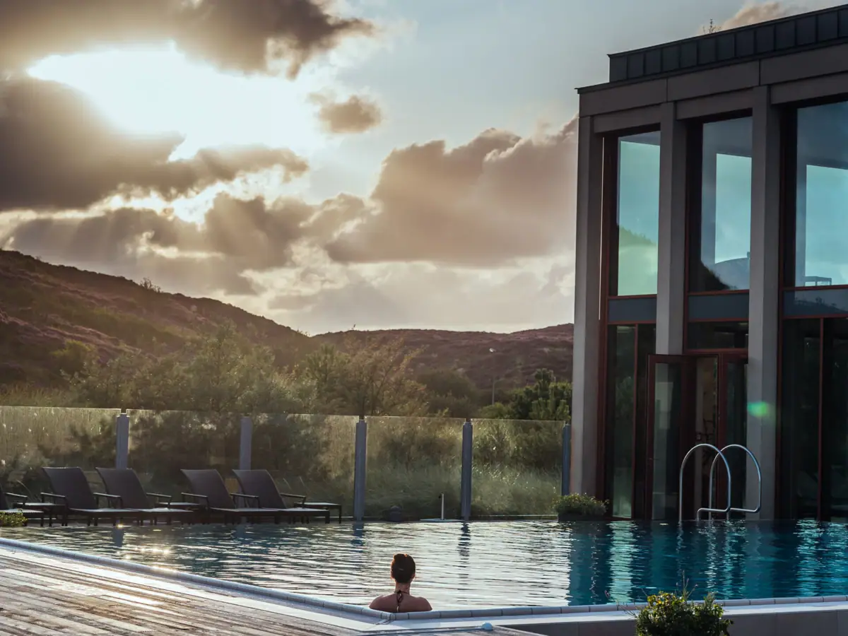Eine Frau in einem Pool mit einem Gebäude im Hintergrund.