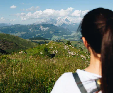 Donna che osserva un paesaggio montano mentre fa escursionismo.