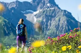 Eine Frau spaziert in einem Blumenfeld.
