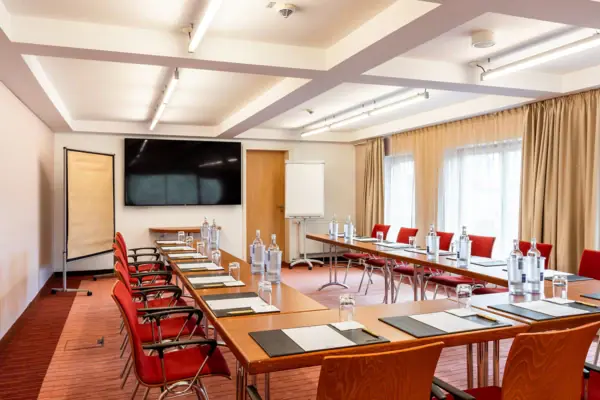 Una sala con tavoli e sedie all’A-ROSA Travemünde.
