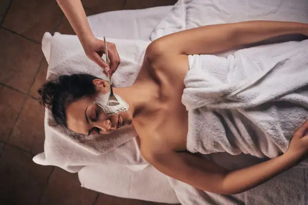 Una donna giace con una maschera sul viso.