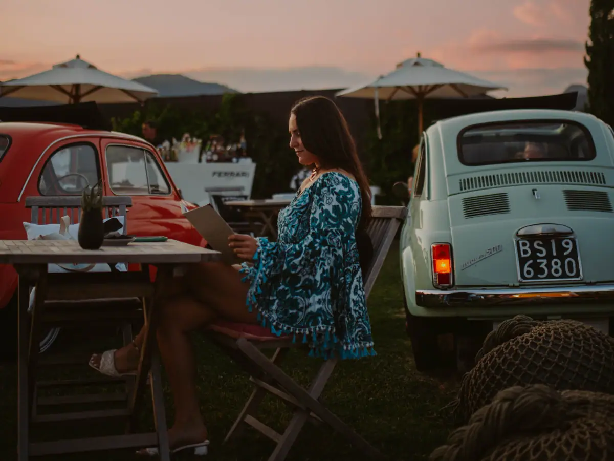 Una donna seduta a un tavolo con un menu.