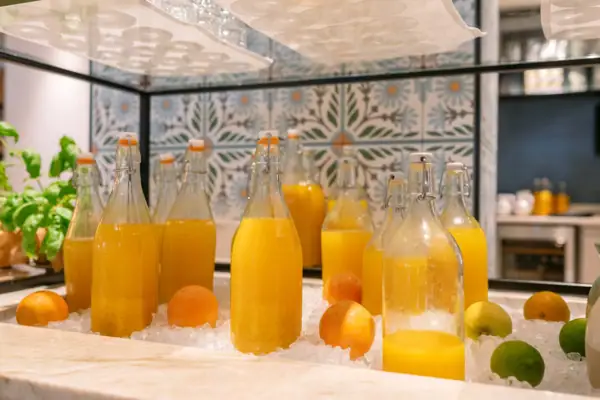 Bottiglie di succo d'arancia e frutta su ghiaccio.