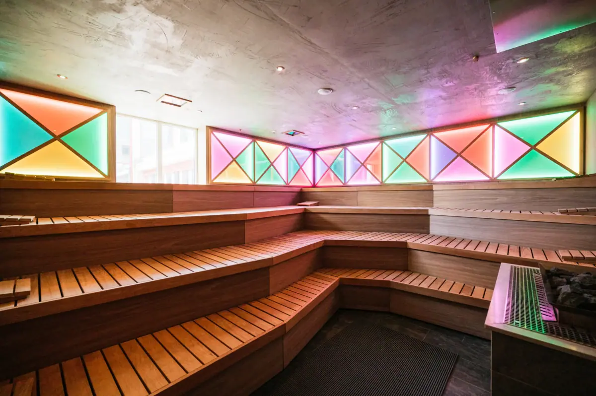 Sala sauna con panche in legno e luci colorate