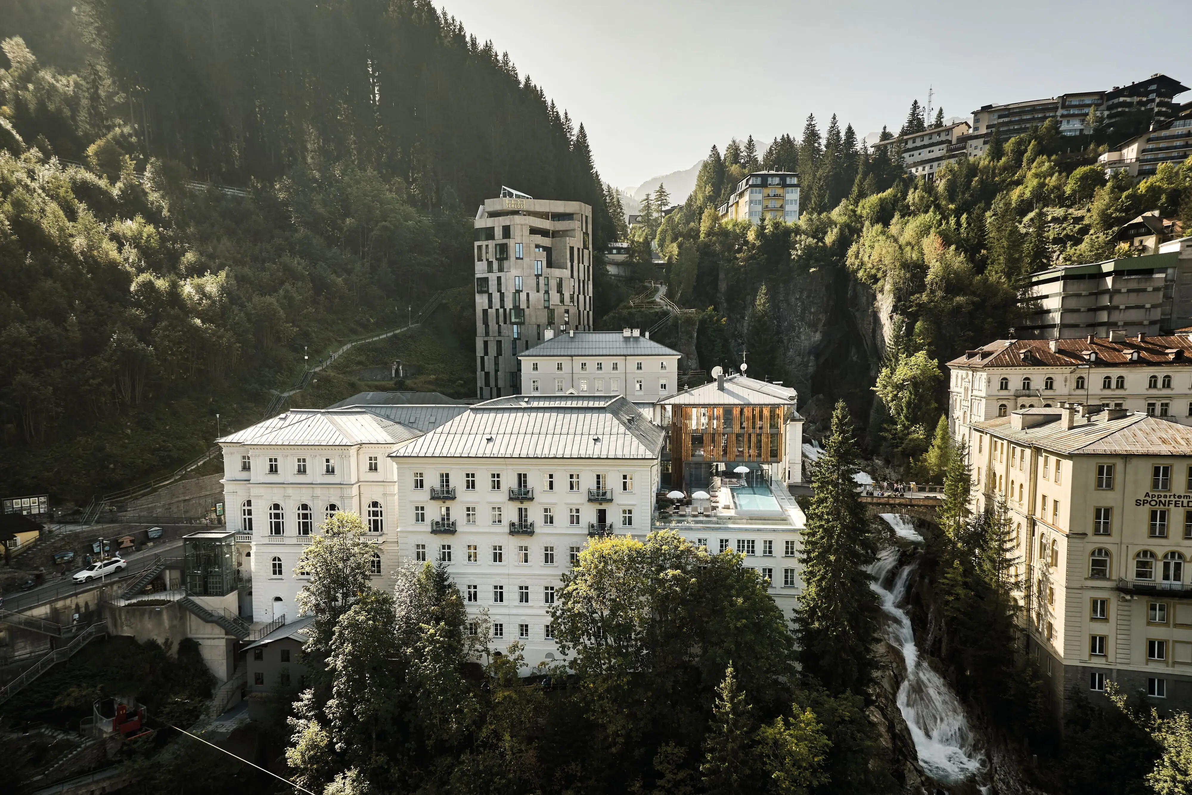 Un gruppo di edifici in una valle con alberi e cielo sullo sfondo.