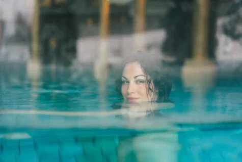 Donna che nuota in una piscina all'aperto.