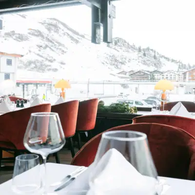 Un ristorante con tavoli apparecchiati e bicchieri da vino.
