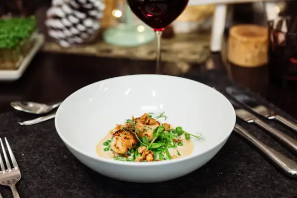 Una ciotola di cibo e un bicchiere di vino.