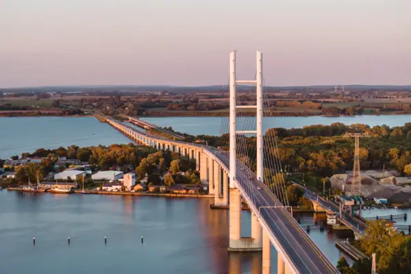 Brücke über Wasser mit Straße und Bäumen im Hintergrund