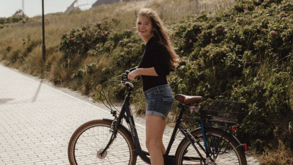 Donna in bicicletta all'aperto.