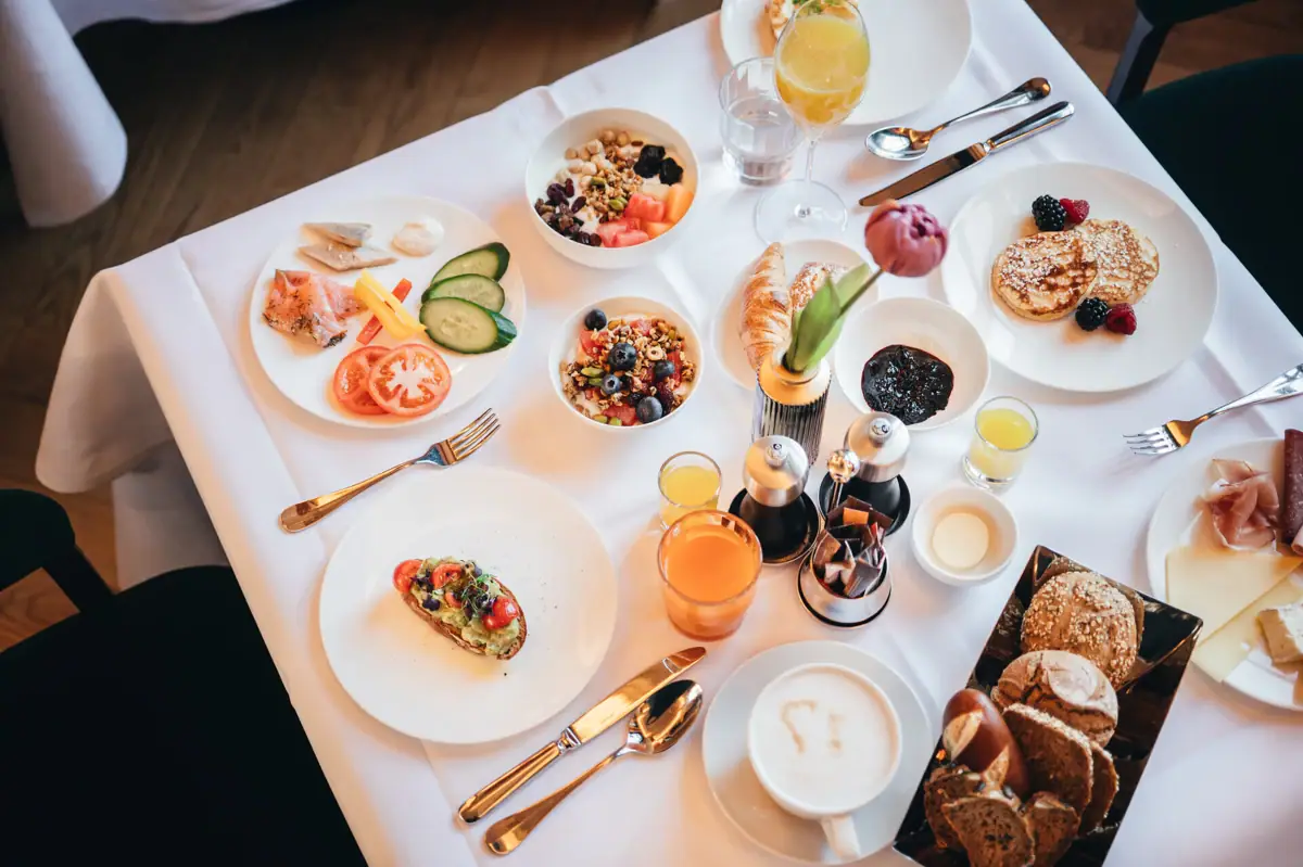 Tavolo apparecchiato con piatti di cibo e bevande.