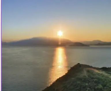 Tramonto sul lago con cielo sereno e orizzonte visibile.