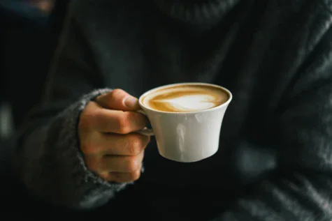 Persona che tiene in mano una tazza di caffè.